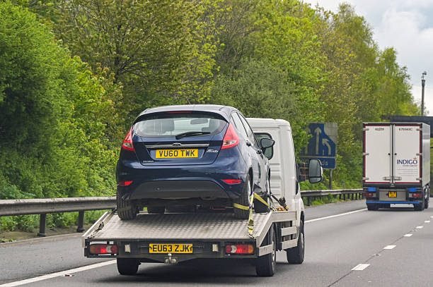 Recovery truck carrying a blue Ford Fiesta along a South East dual carriageway